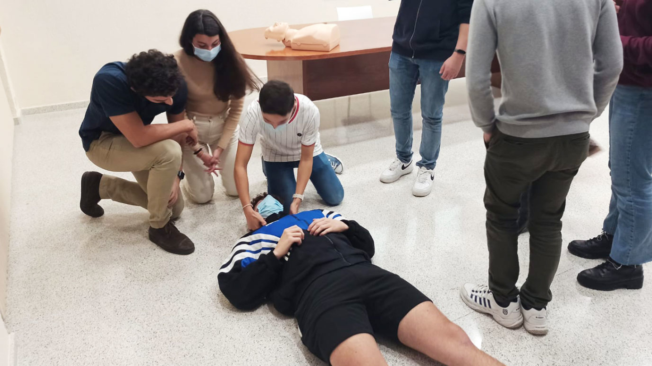 estudiantes hacen una maniobra de primeros auxilios