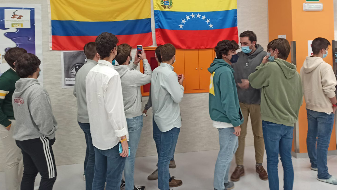 colegiales miran la bandera de colombia y venezuela