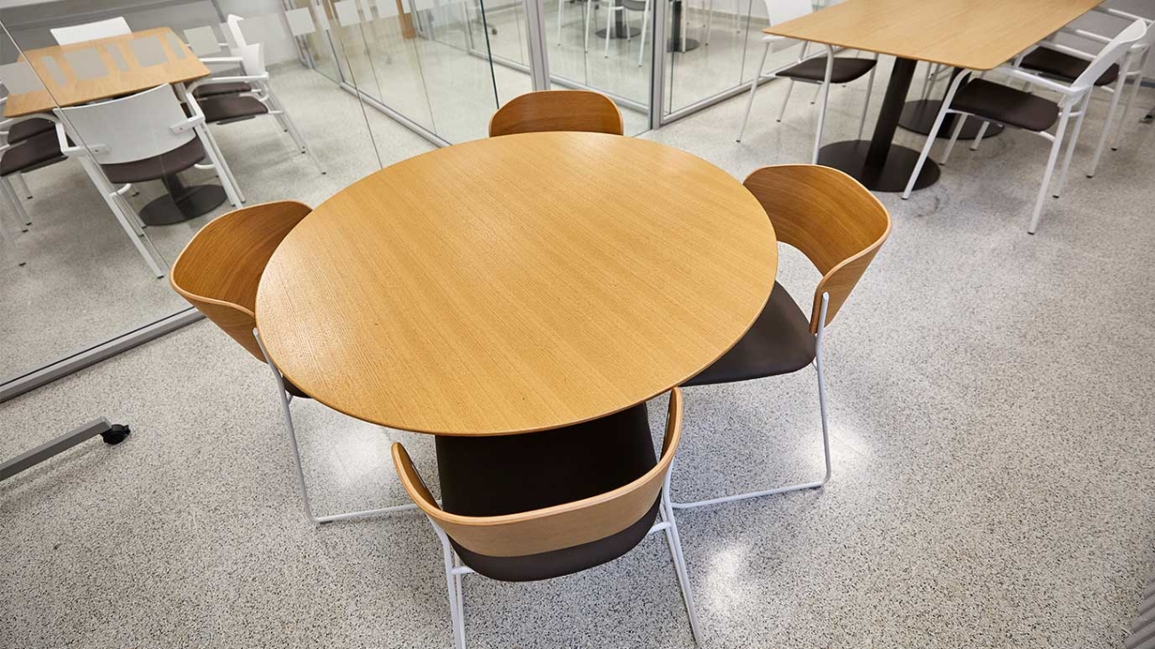 mesa redonda con cuatro sillas en la sala de estudio