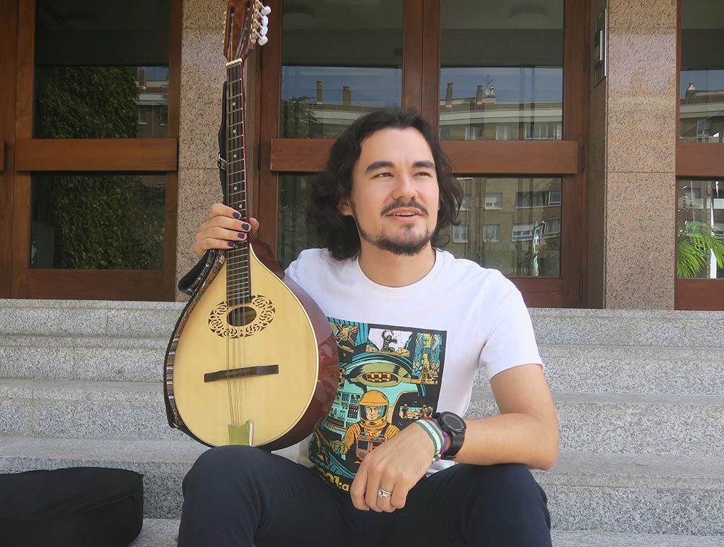 a student with a mandoline sitting in the porch of colegio mayor larraona