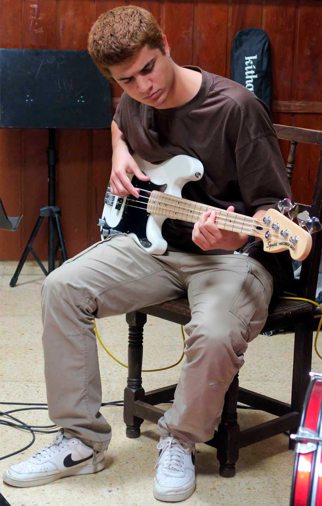 un estudiante toca el bajo