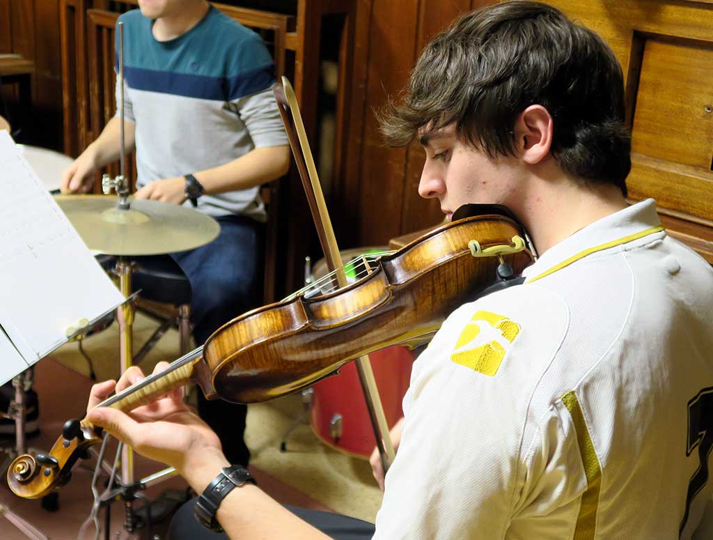 estudiante universitario toca el violín