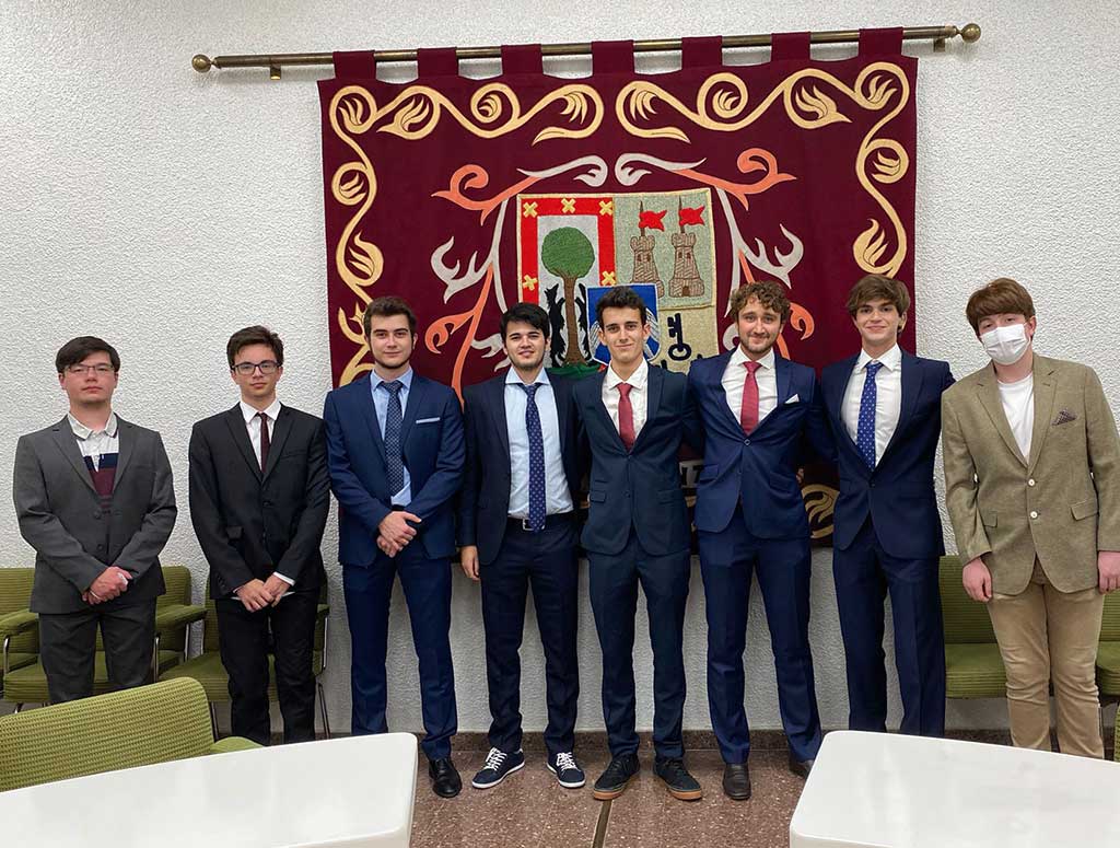 colegiales de traje frente al escudo de larraona