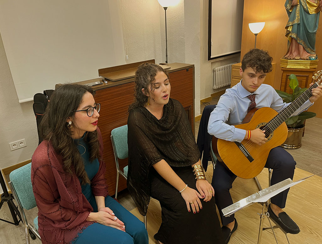 dos chicas cantando y un chico toca la guitarra