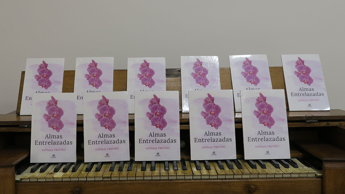 Varios libros de Almas Entrelazadas sobre un piano