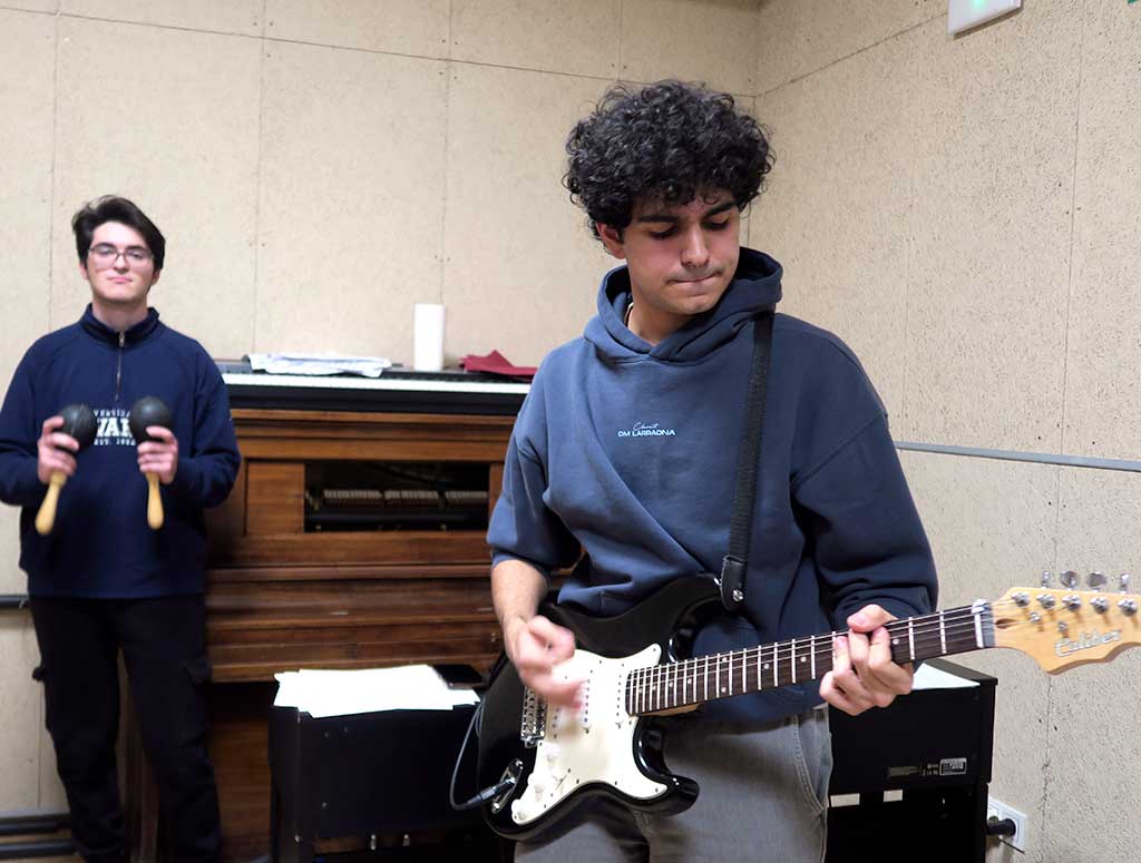 un estudiante toca la guitarra en el colegio mayor