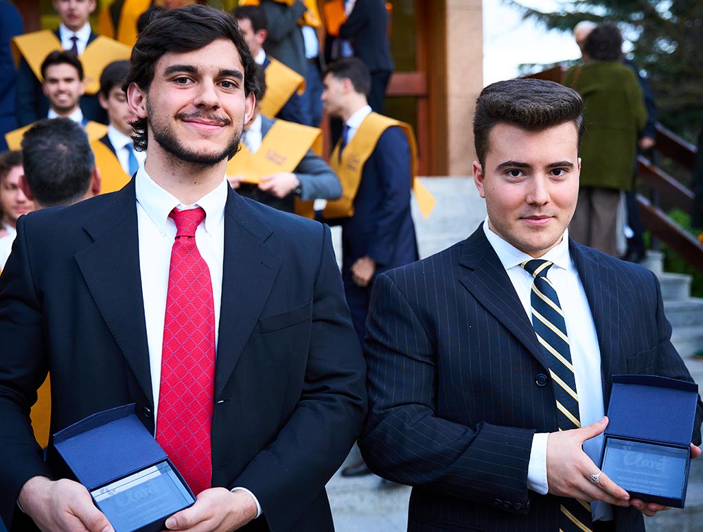 dos colegiales con las placas de fin de carrera