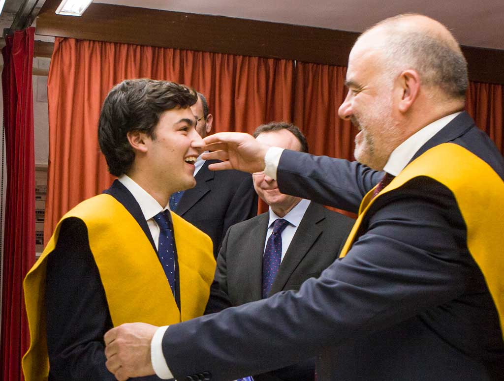 director del colegio mayor impone la beca en un colegial